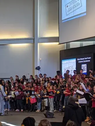 Maria Ellis leads a group of students singing together in Phoenix