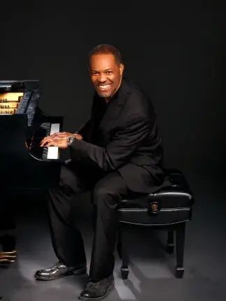 Roger Holland smiling at piano